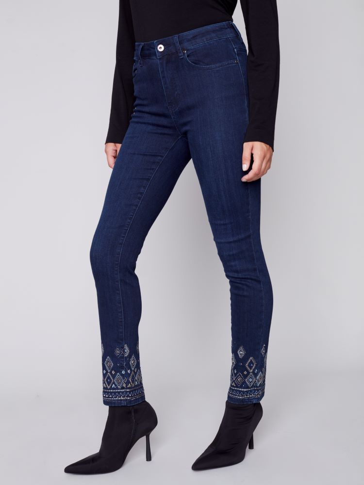 Elevate your seasonal wardrobe with Charlie B's Blue Black jeans. Exquisite geometric embroidery and embellishments adorn the hem, while a slim leg, regular rise and stretch material provide a comfortable fit with five convenient pockets.