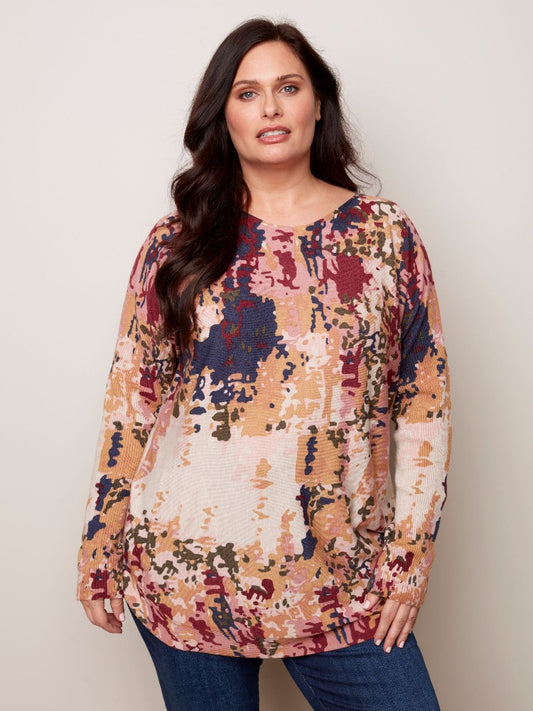 This tunic-length Charlie B Plus Long Sleeve Printed Sweater has so much for you to love.   Super comfy material, a rounded hem, ribbed sleeves as well as an eye-catching tie-dye print and it even has pockets! 